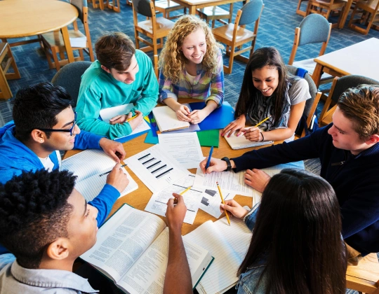 Students gather a table to discuss their studies overseas and exchange ideas in a supportive environment.